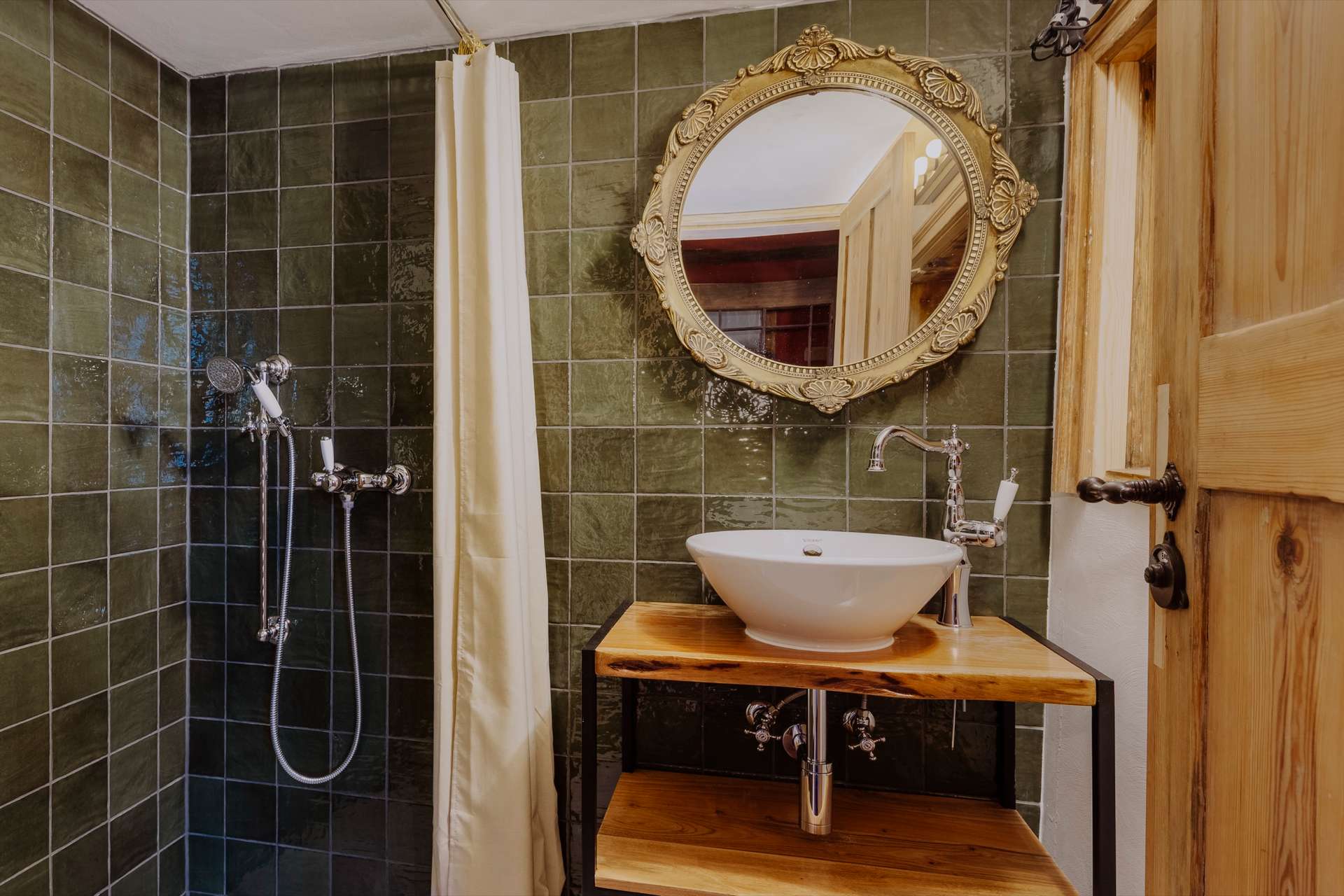 Duschbad mit waldgrünen Fliesen, Walk-In-Dusche, Holzkonsole mit Aufsatzwaschbecken und prunkvollem Goldspiegel