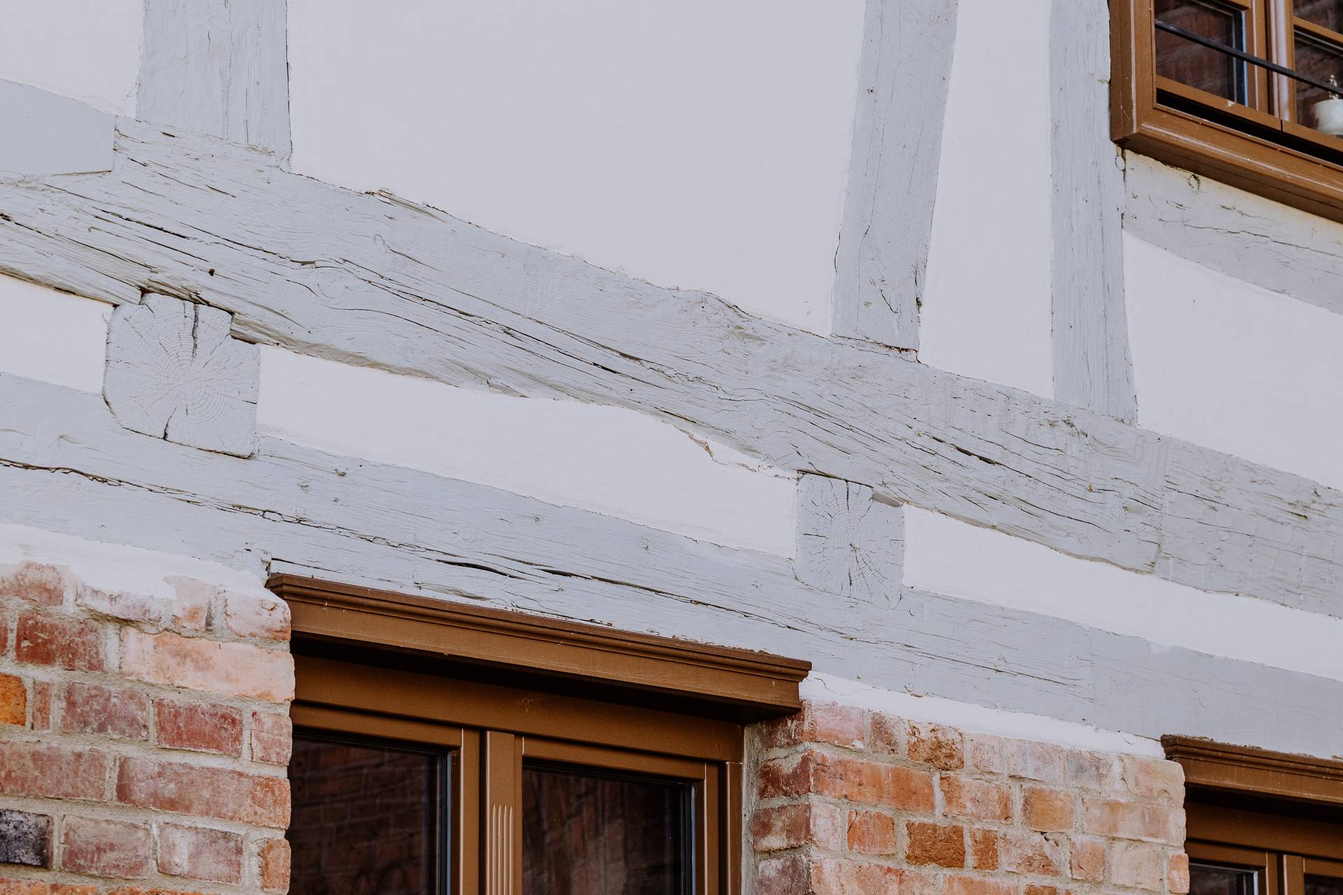 Detailaufnahme des restaurierten historischen Holzfachwerks mit traditionellem Ziegelmauerwerk